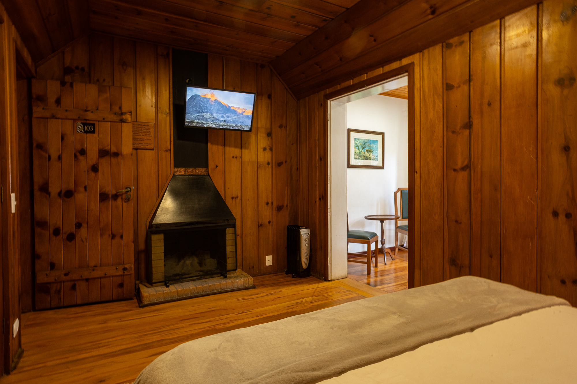Quarto 103 — Lareira e acesso à sala